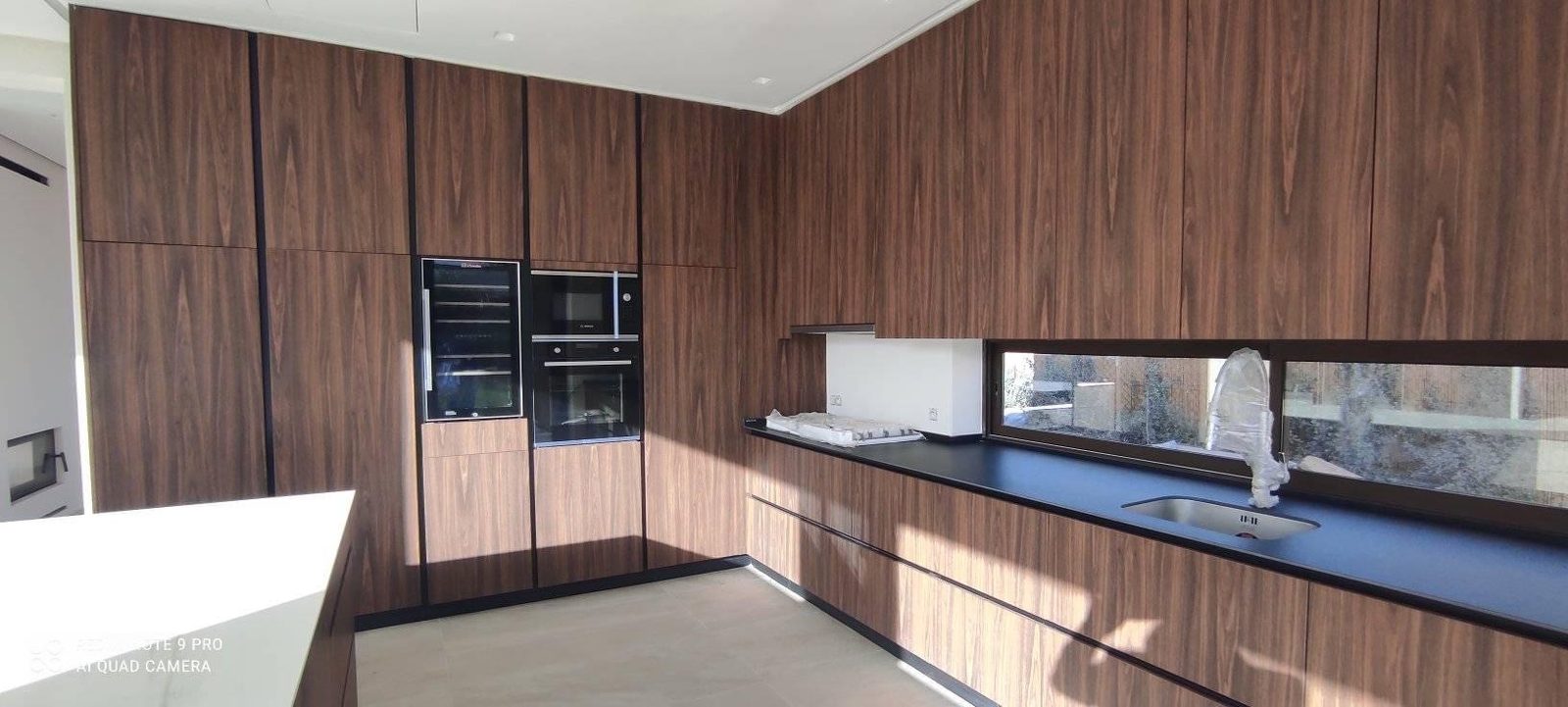 Cuisine d’angle à façades bois et plan de travail foncé